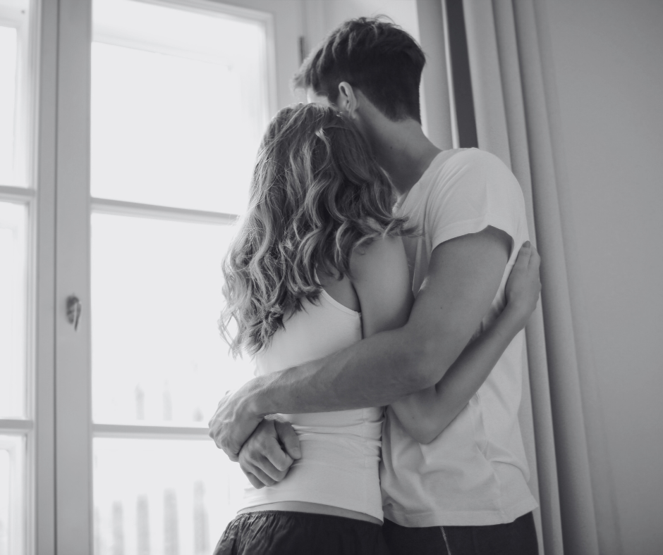 Couple embracing by window, morning light