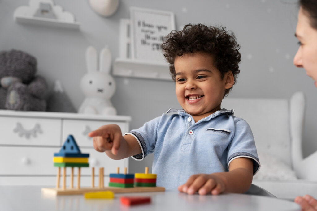 Happy child playing with colorful building blocks at a table.