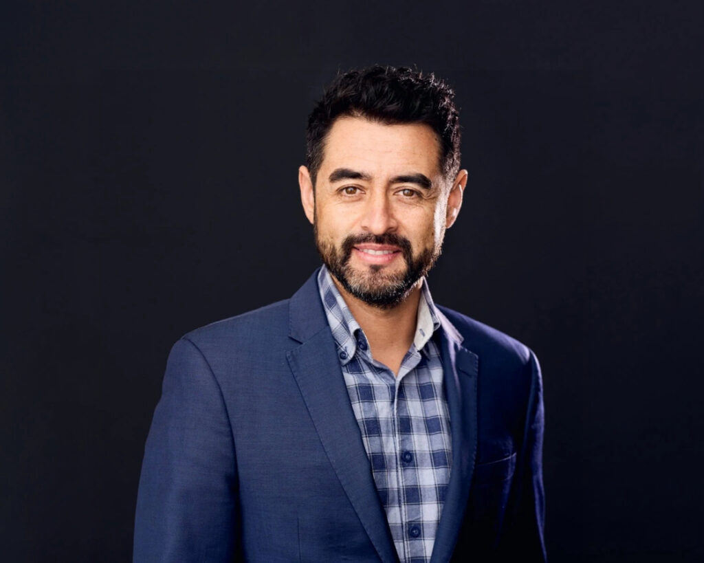 Friendly headshot of a male immigration lawyer.
