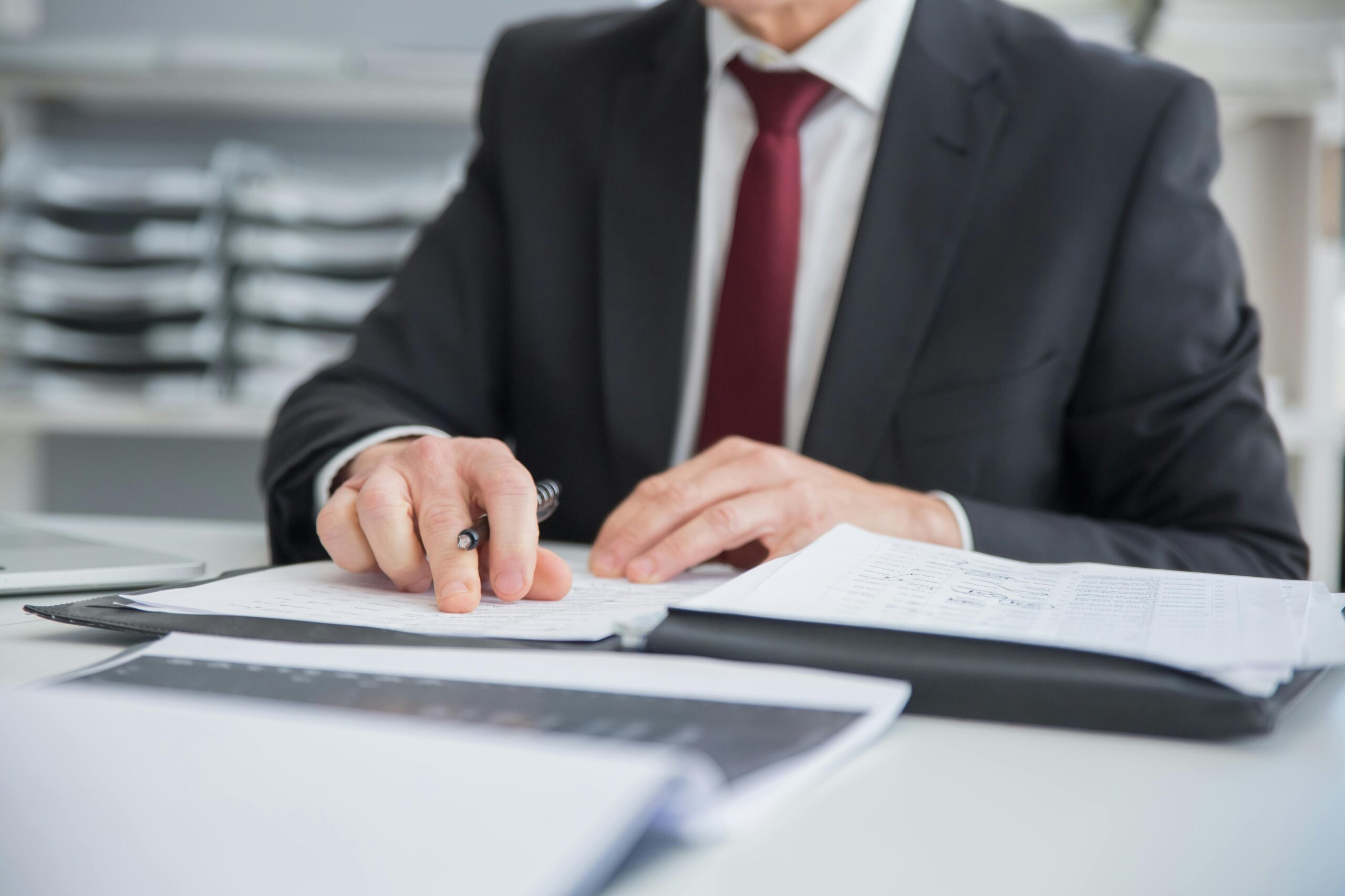 Businessman reviewing documents, preparing for administrative review tribunal appeal.