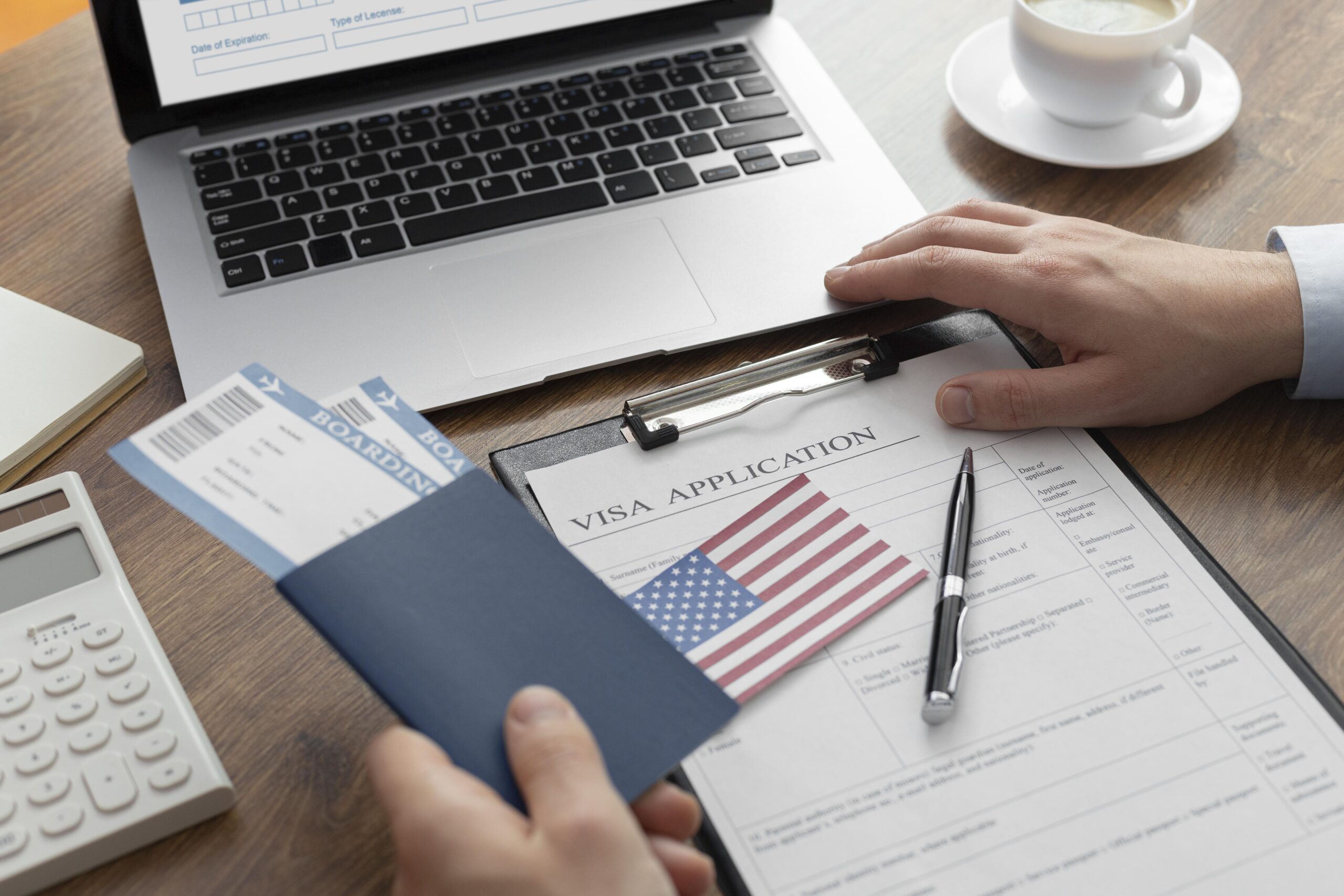 Person completing a visa application, holding passport and plane tickets.