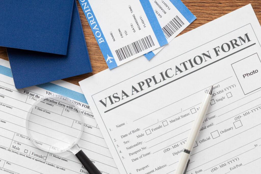 Visa application form, passport, boarding pass, and pen; working visa refusal.