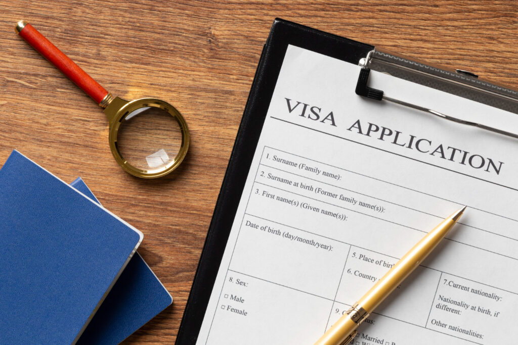 Visa application form with passport and pen. Section 116 visa cancellations.