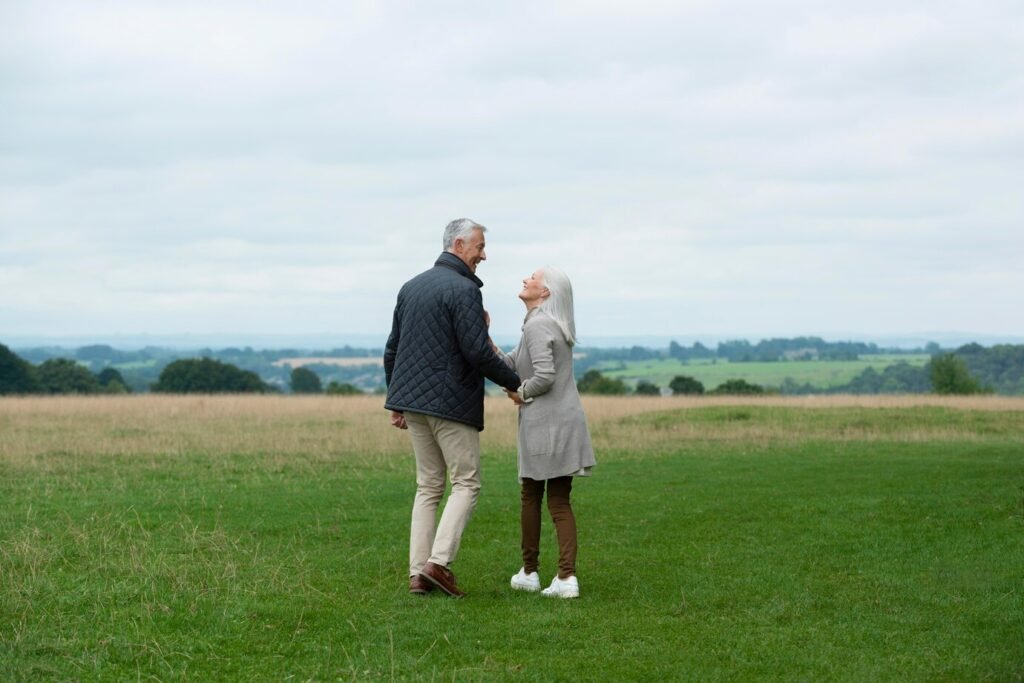 Happy senior couple holding hands, enjoying a scenic view.