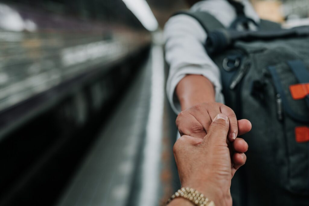 Two hands holding each other, symbolizing support and hope for immigration.