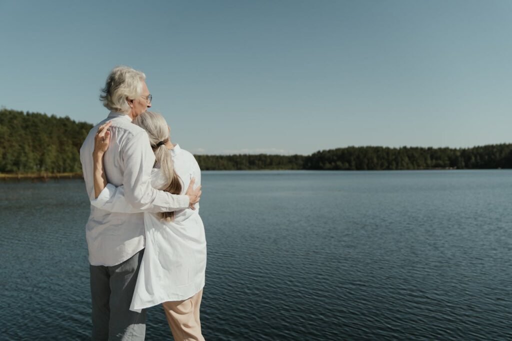 Senior couple embracing by a lake.