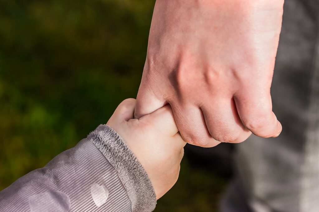 Close-up of an adult and child holding hands.