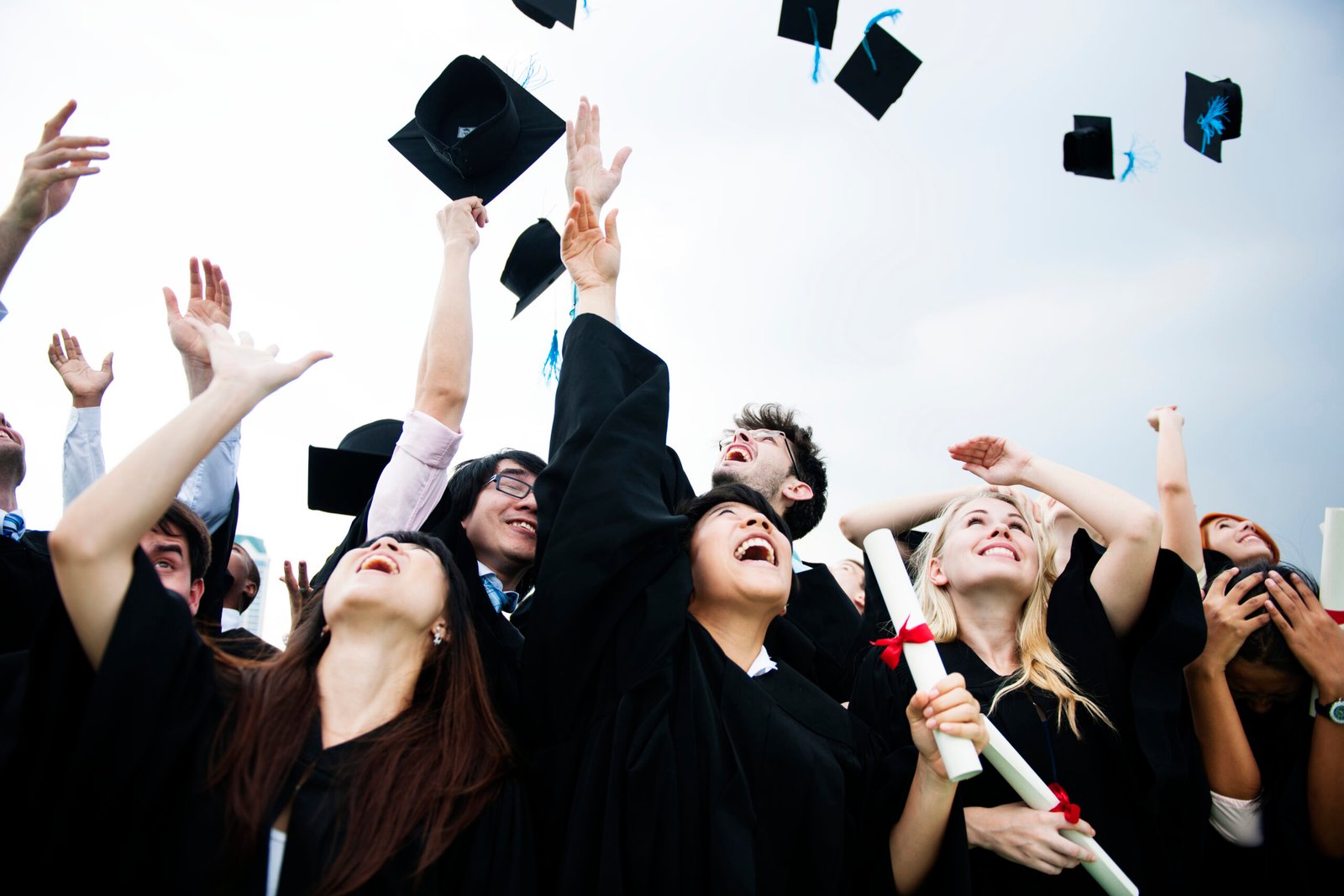 Graduates joyously throwing caps in the air, celebrating academic achievement