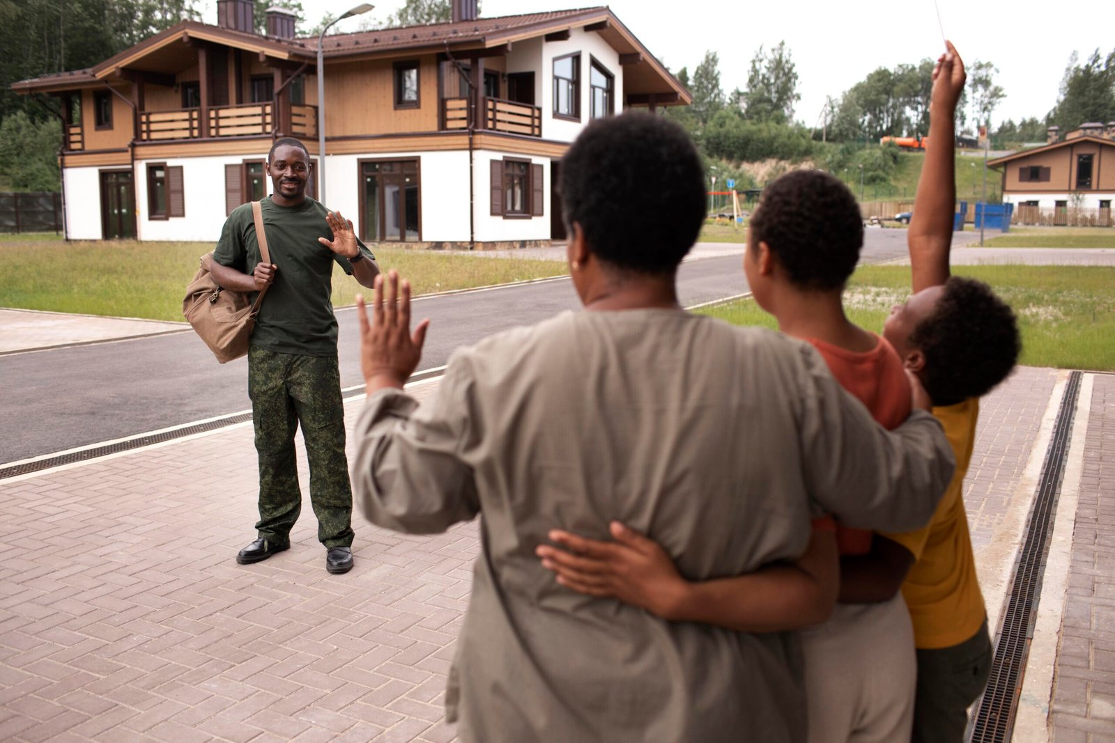 Happy family greeting a soldier returning home near their new house in regional South Australia.