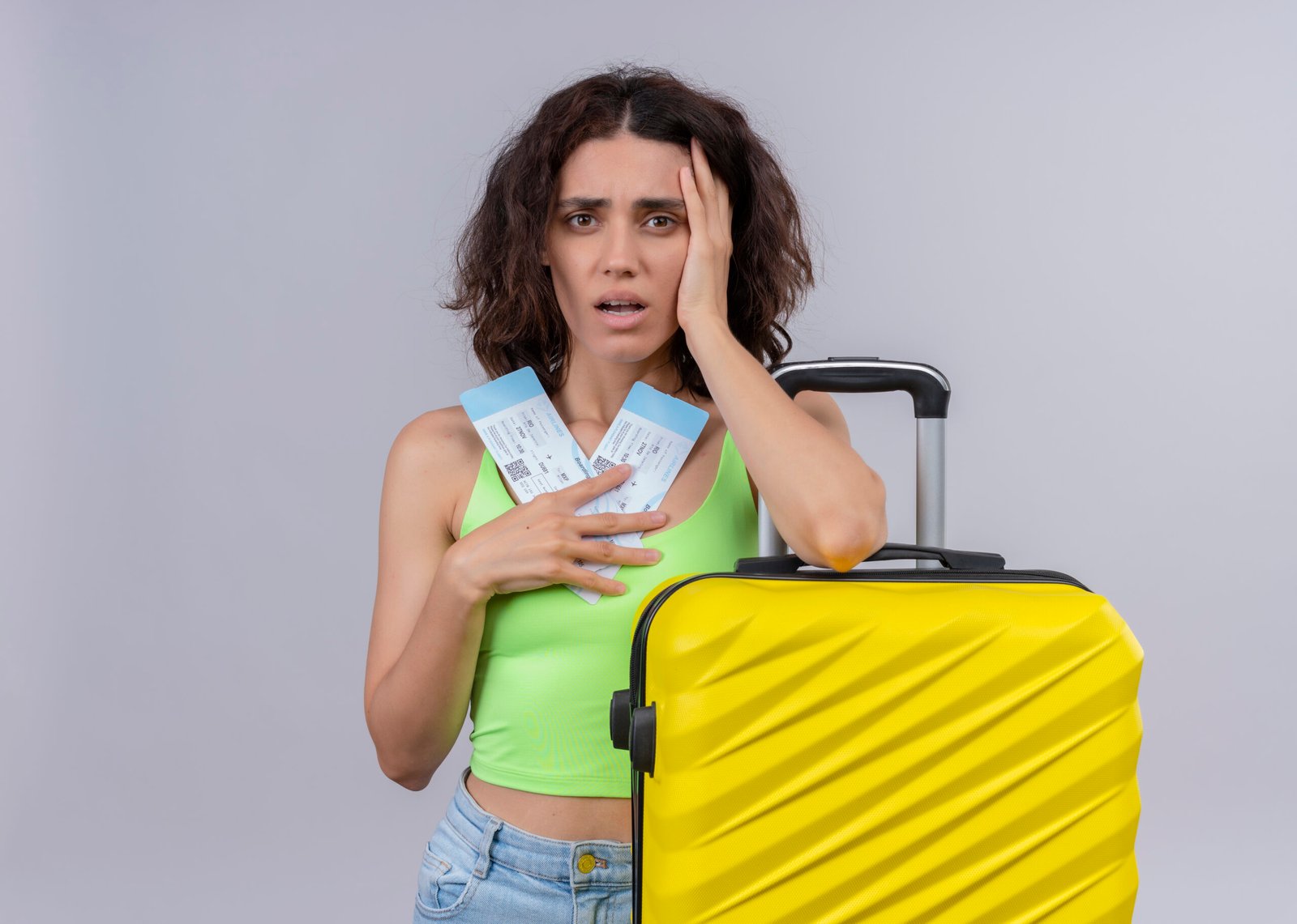 Worried woman with plane tickets and yellow suitcase. Visitor visa cancellation concept.