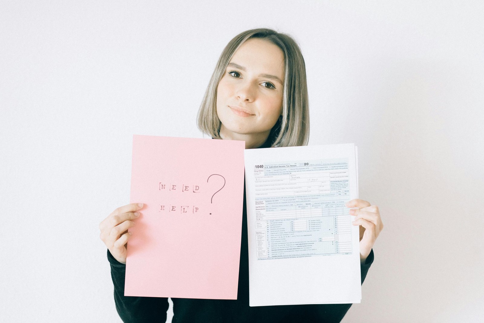 Woman holding tax form 1040 and a sign that says "Need Help?". Partner visa hearing prep.
