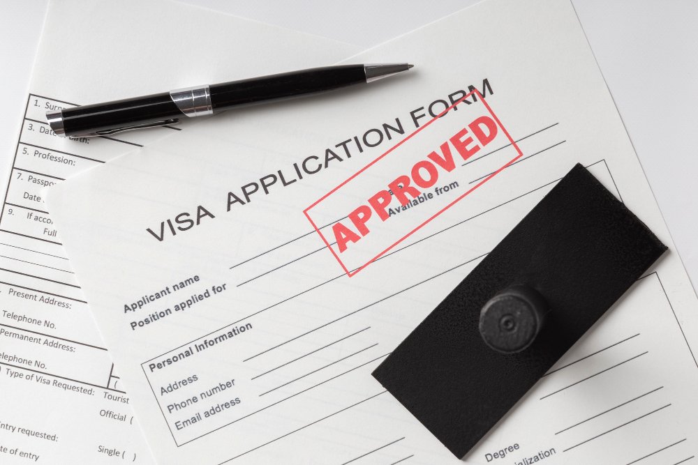 Visa application form stamped "APPROVED" with a pen and stamp.