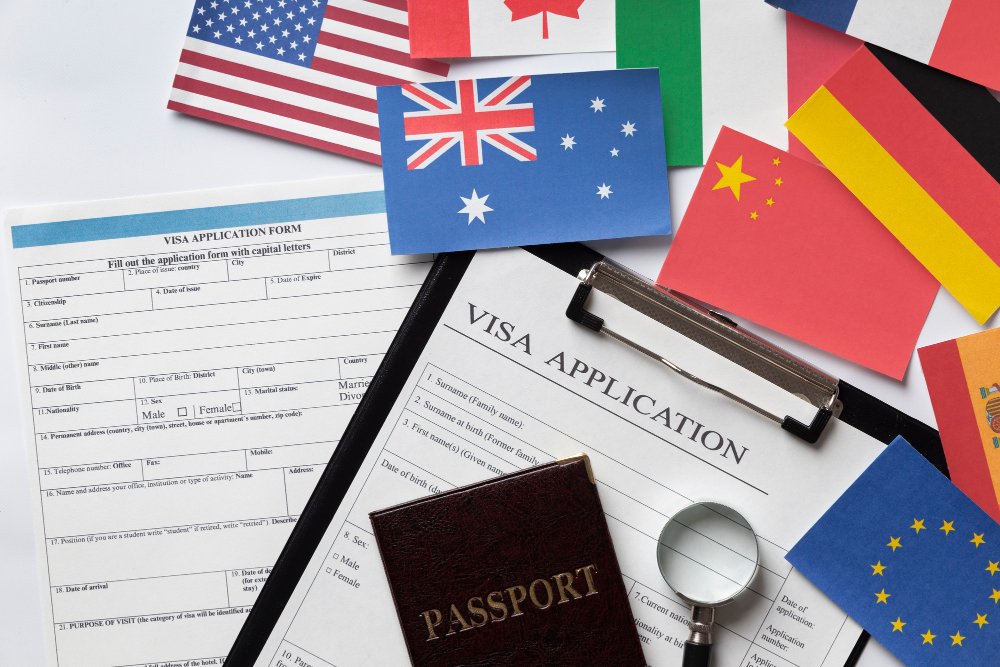Visa applications, passport, and flags, representing applying for Australian citizenship by descent when born overseas.