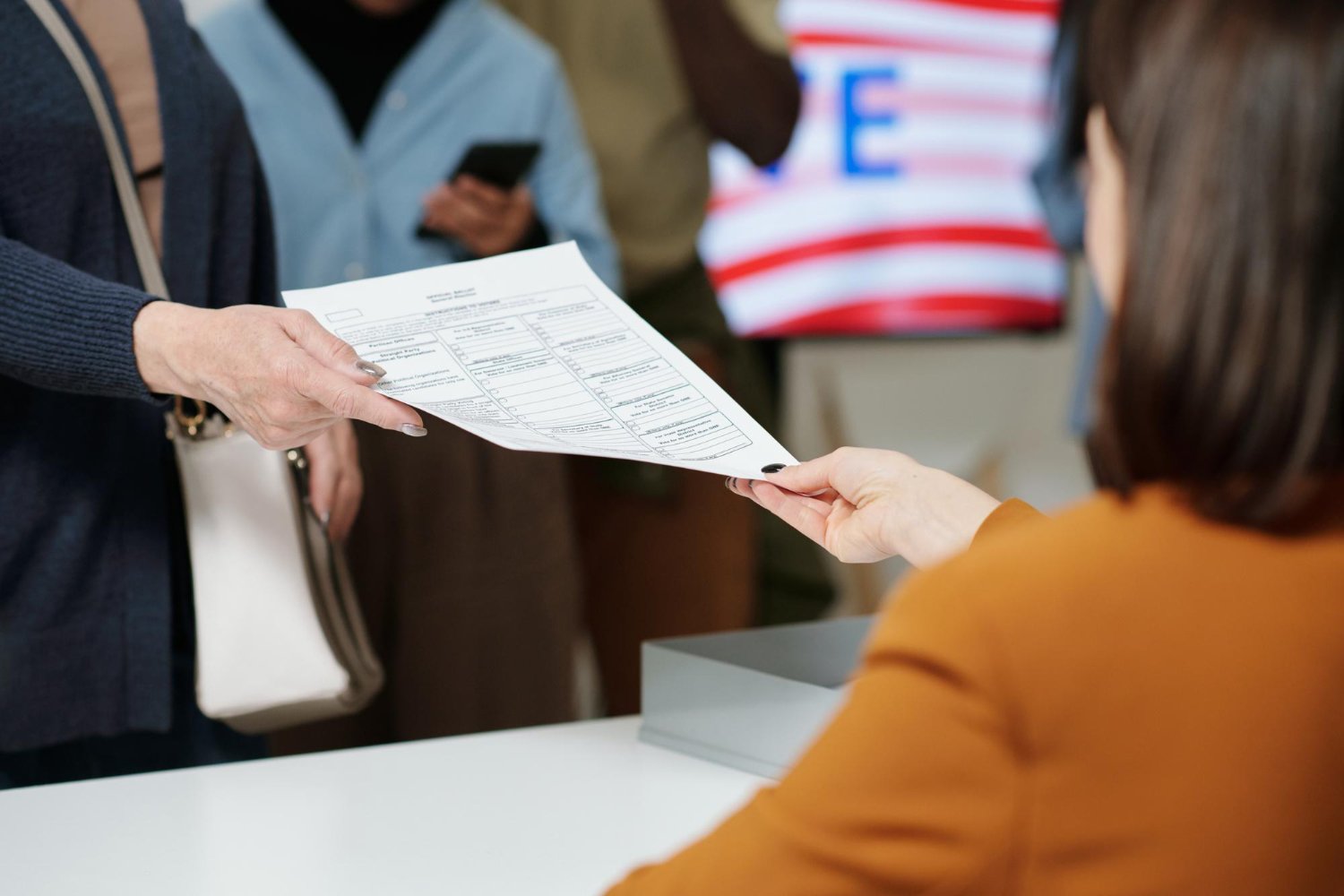 Person handing in a ballot paper at a polling station.
